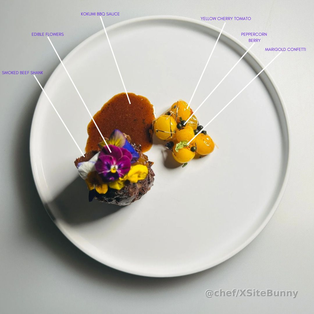 Smoked beef shank, taken to a floral high note.

This dish pairs tender smoked beef shank with kokumi BBQ sauce, finished with a vibrant crown of edible flowers. On the side, yellow cherry tomatoes dressed with peppercorn berry and marigold confetti bring brightness and contrast.

A balance of power and delicacy—rustic BBQ elegance plated with intention.
