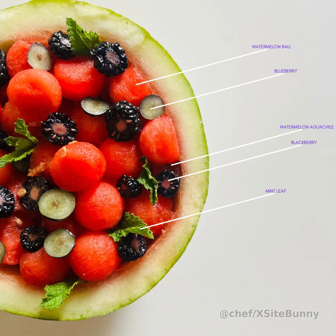 A refreshing burst of summer in every spoonful.

This watermelon aguachile is served in its own shell, packed with juicy watermelon balls, blackberries, blueberries, and fresh mint leaves. Sweet, tangy, and vibrant with just the right touch of heat—it’s fruit salad reimagined